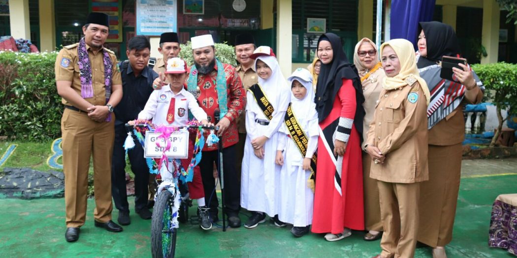 Walikota Helmi saat menyerahkan bantuan sepeda kepada murid SDN 8 Kota Bengkulu.