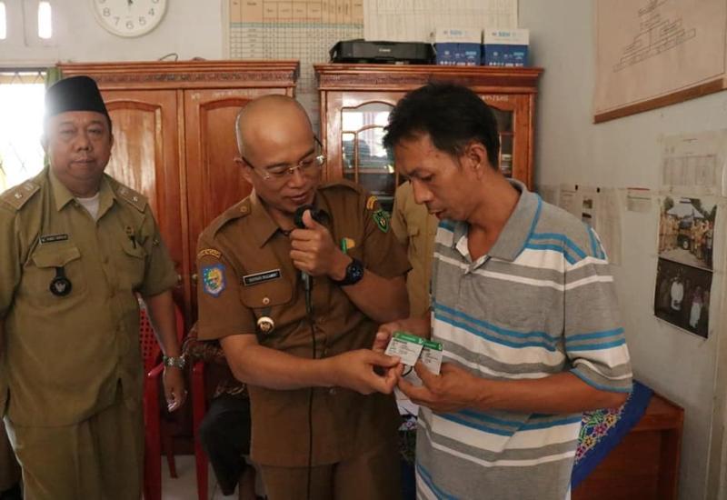 Petugas Dinsos saat memberikan KIS kepada warga