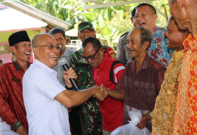 Bupati Gusnan saat menyerahkan bibit lele kepada warga.
