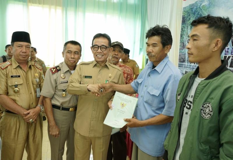 Bupati Hidayatullah saat menyerahkan sertifikat tanah.